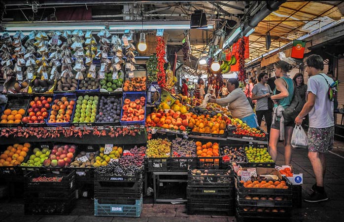 Både turister och lokalbefolkning handlar frukt vid Bolhão-marknaden © Celine181