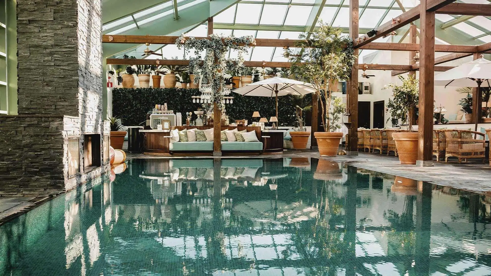 View of pool inside a hotel's wintergarden decorated with plants