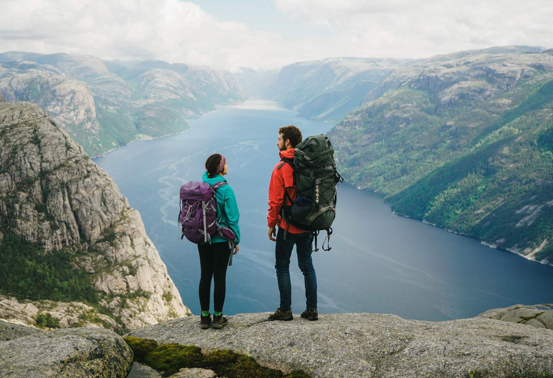 Couple hiking near Preikstolen and looking at Lysefjorden, Norway