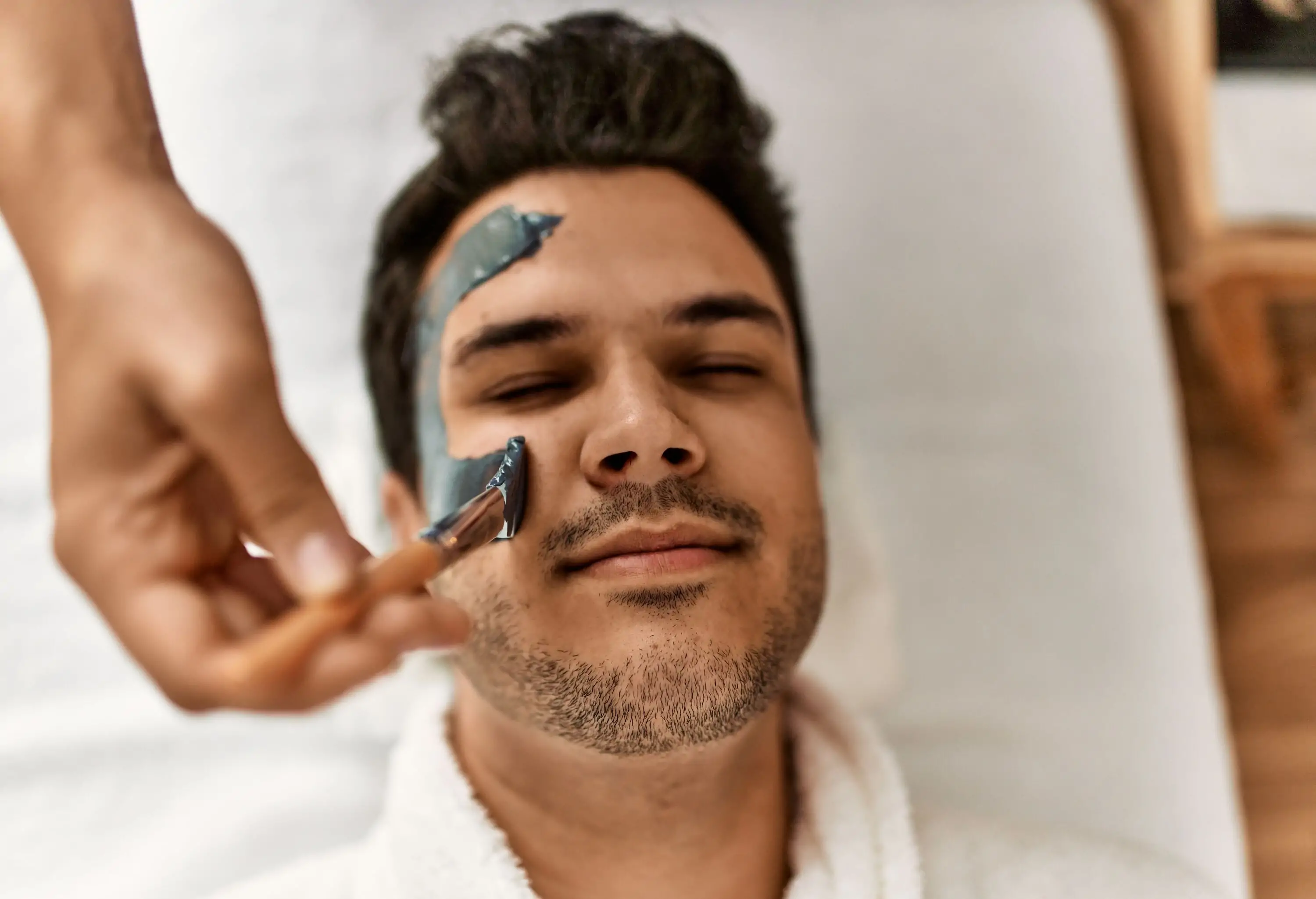 Man reciving facial treatment at spa