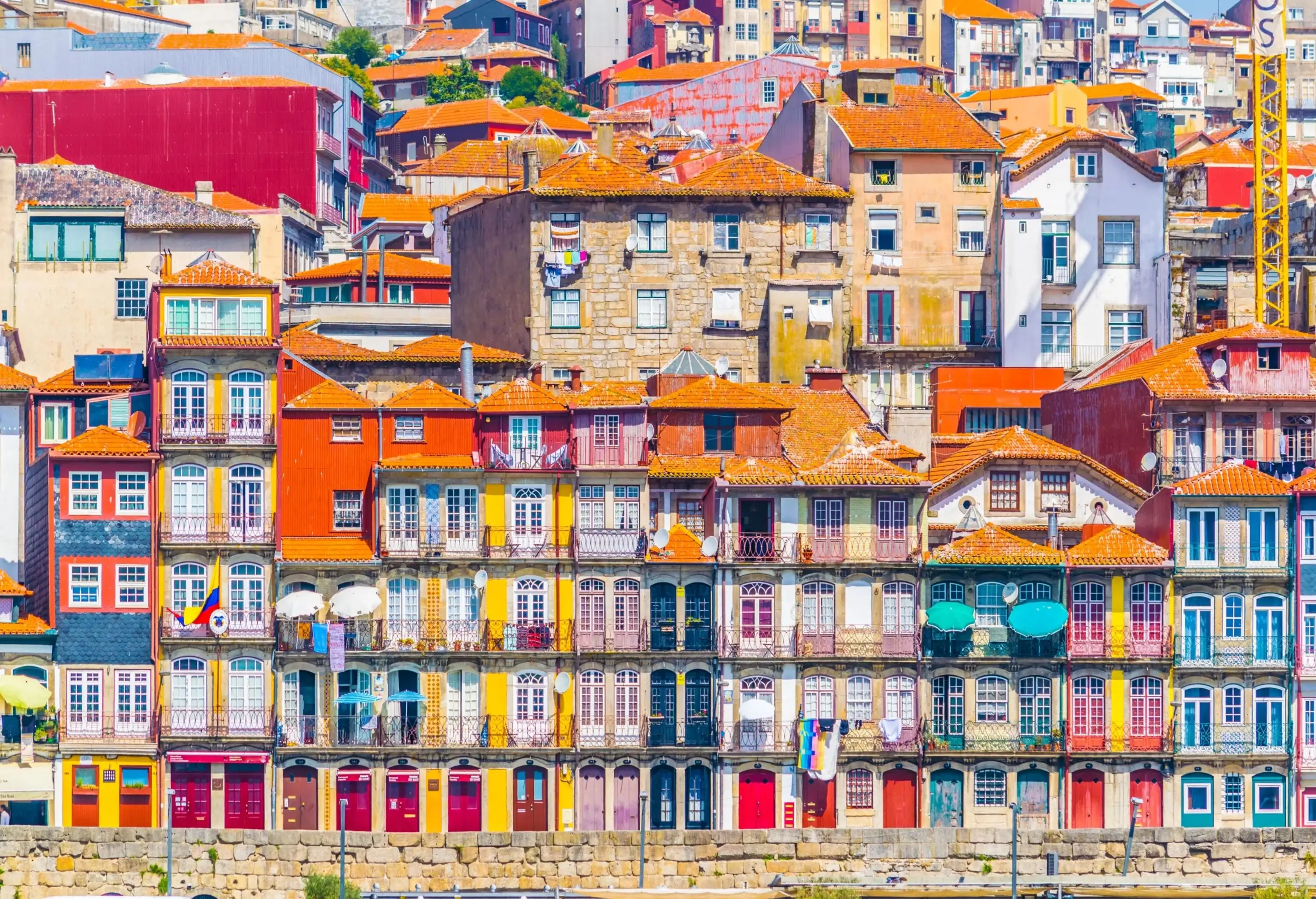 Colourful houses cascade down the gentle slope along the river, forming a colourful and captivating display.