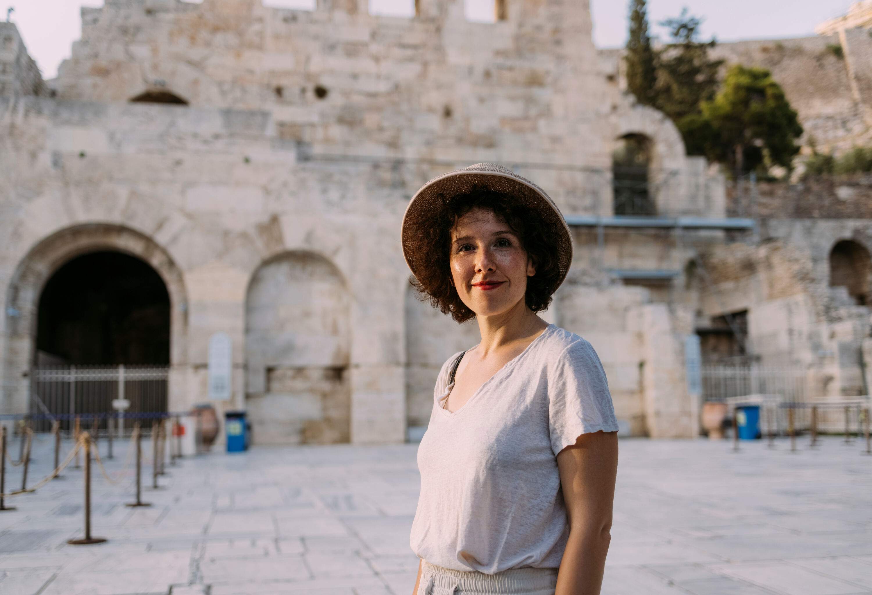 A portrait of a happy woman in front of a museum.