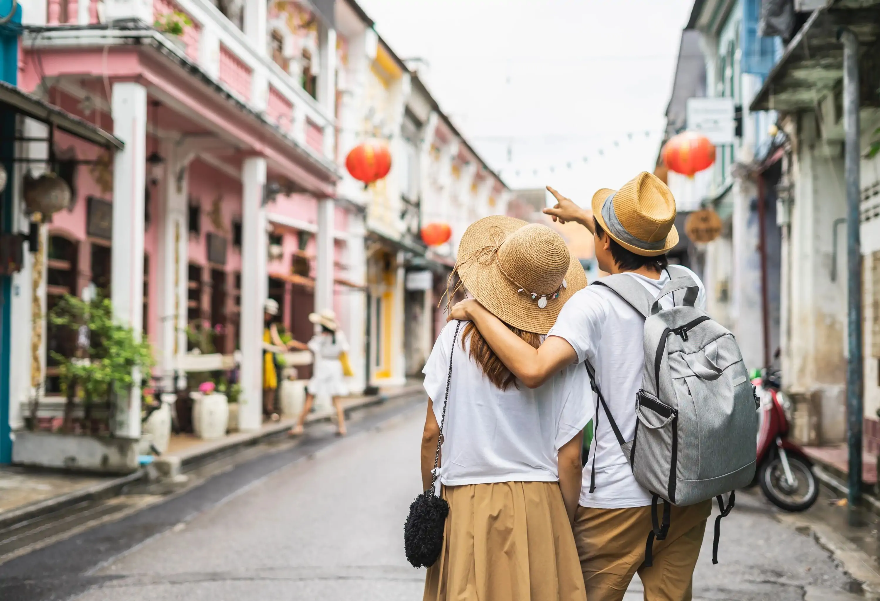 A hat-wearing pair strolling in an alley, surveying the surrounding architecture.