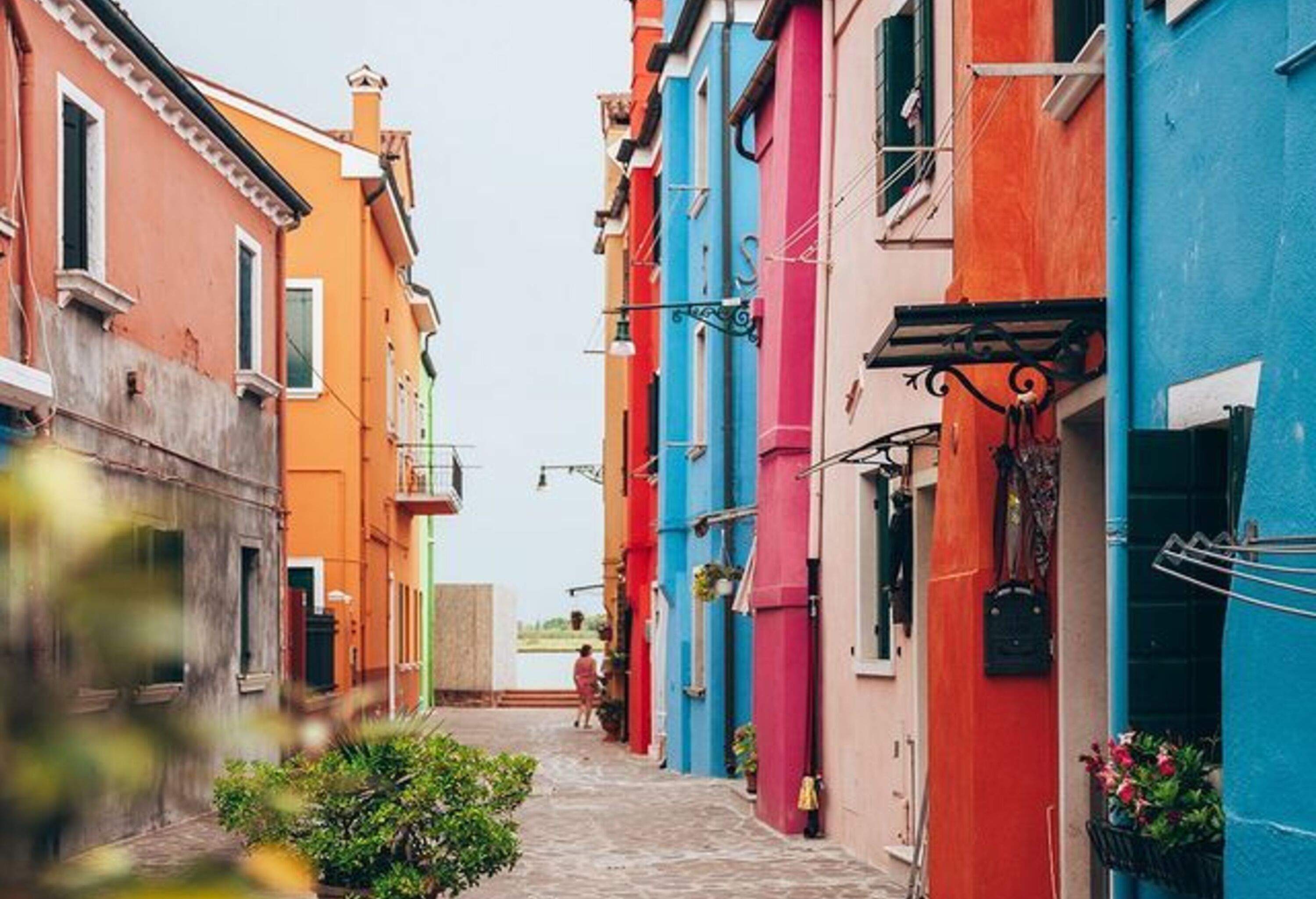 A neighbourhood street across a row of colourful adjacent buildings.