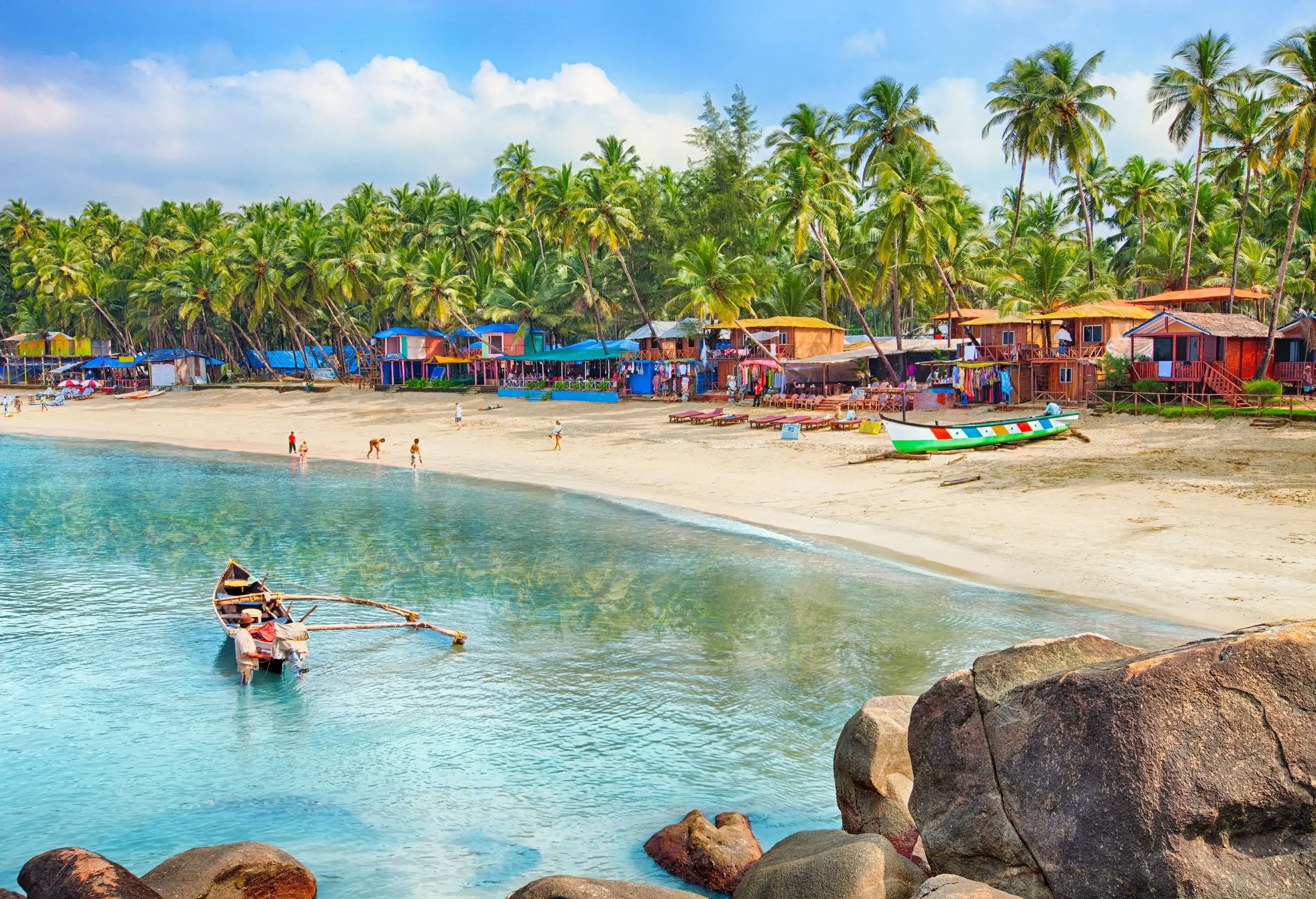 A seaside village with colourful houses concealed in the lush palm trees on the sandy beach.