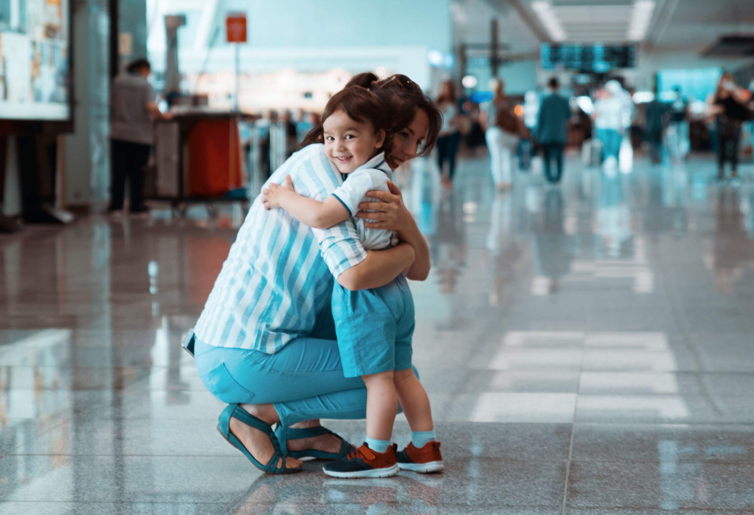 A mother and son beaming with joy as they embrace one other.