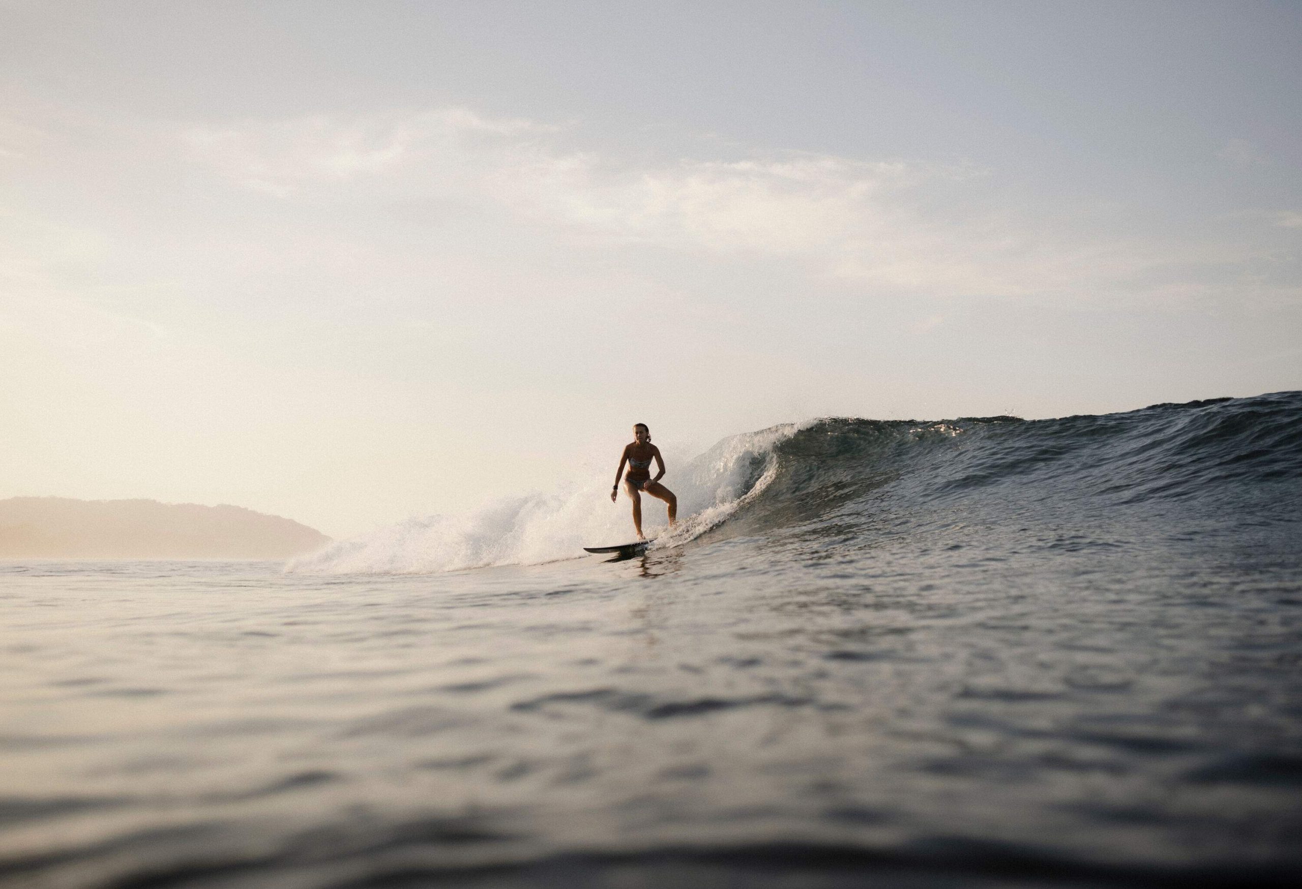 Silhouette of a surfer riding the waves with a surfboard.