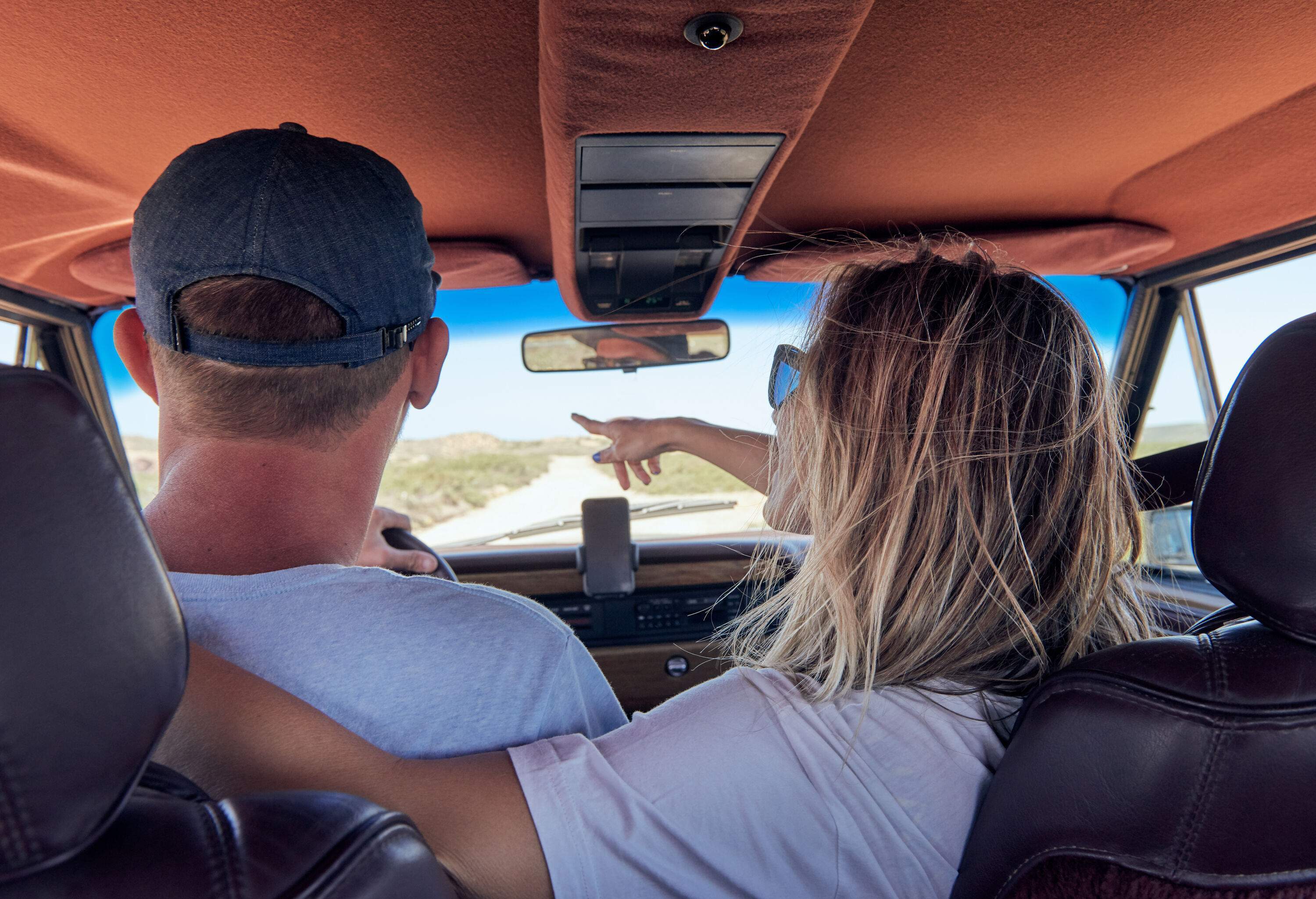 A couple enjoying each other's company inside a car shares a moment of togetherness while travelling.