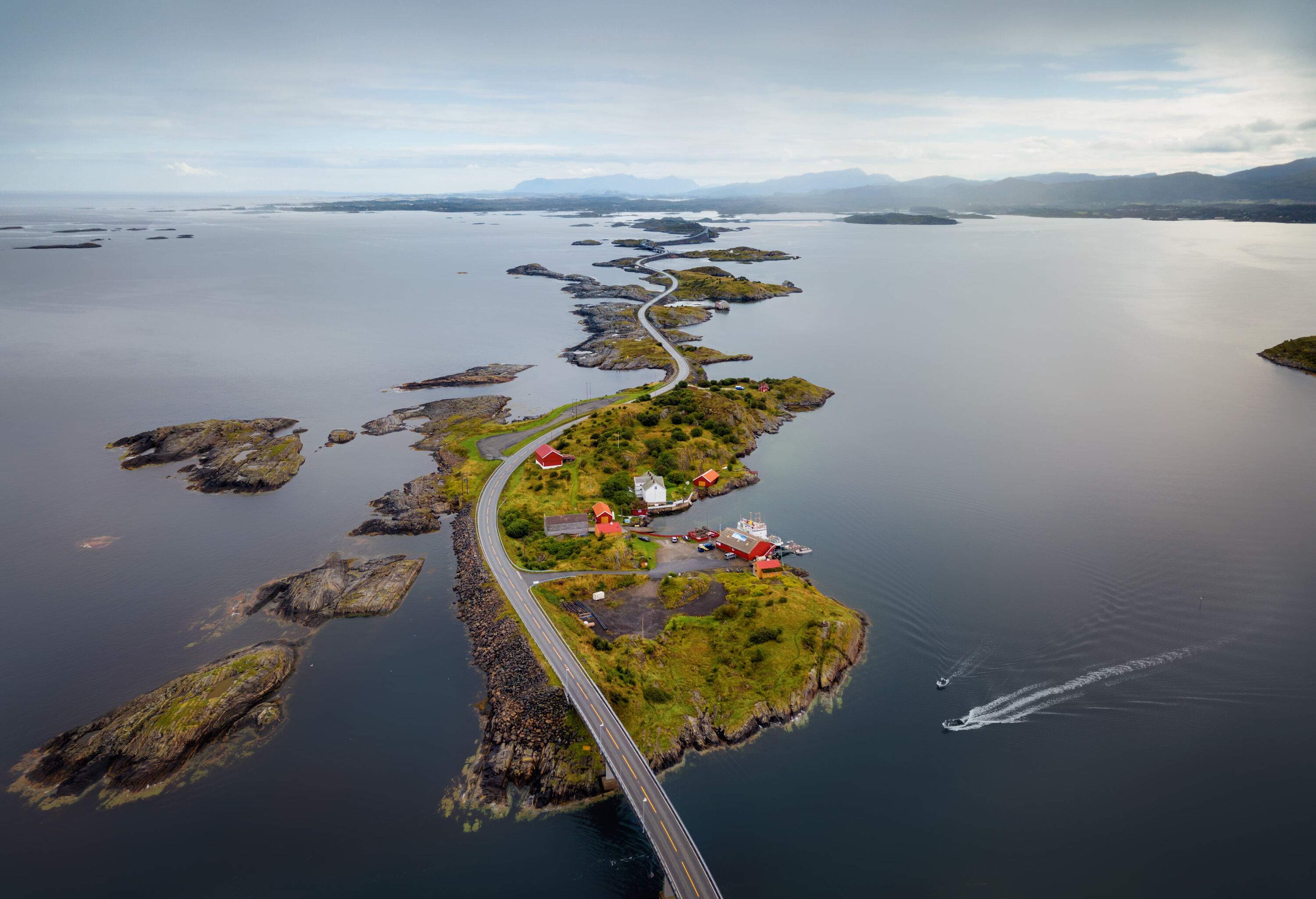 A long road meanders through the islands across the ocean, linked by a bridge.