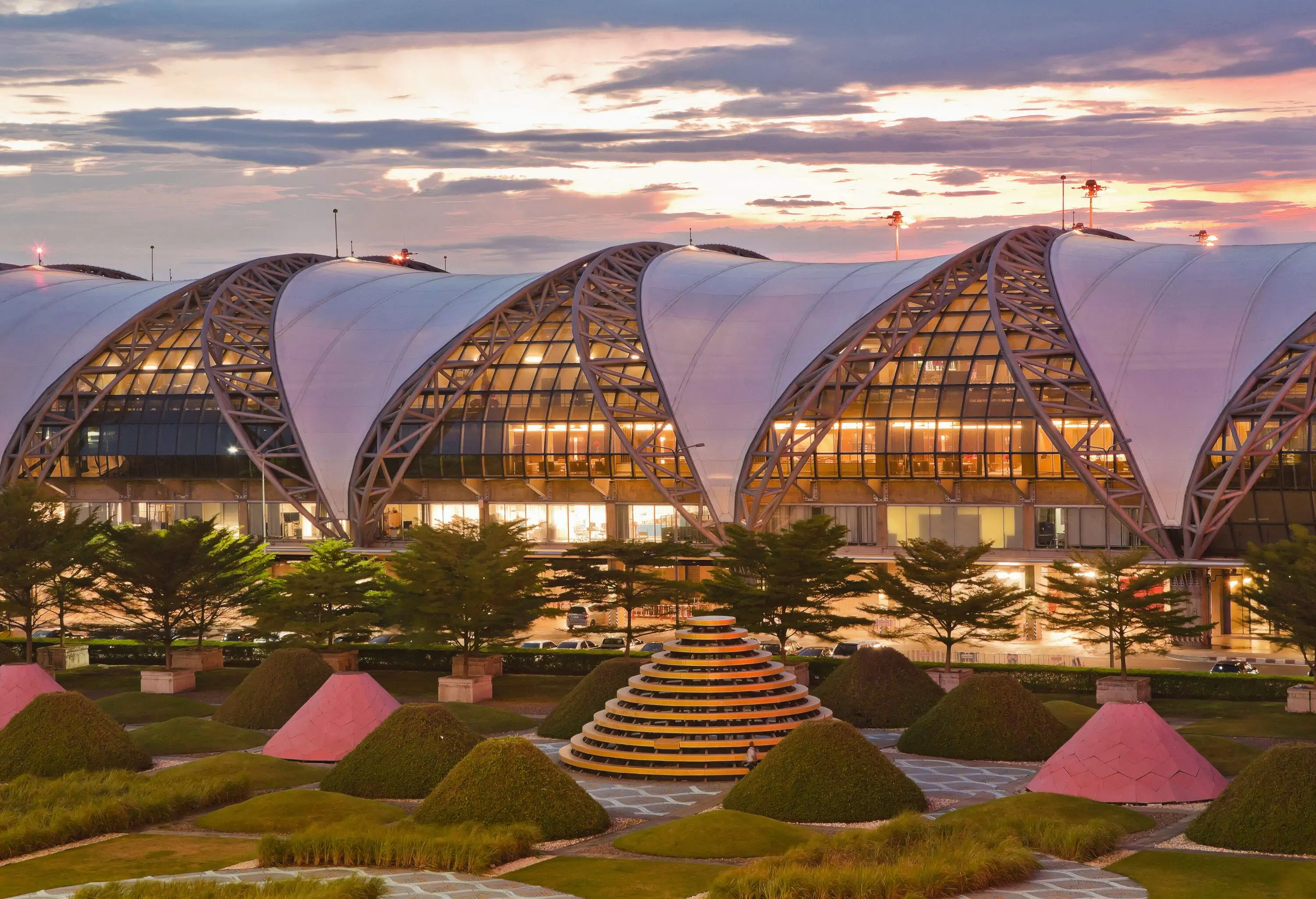 A concourse with glass walls and curved trusses over the roof.