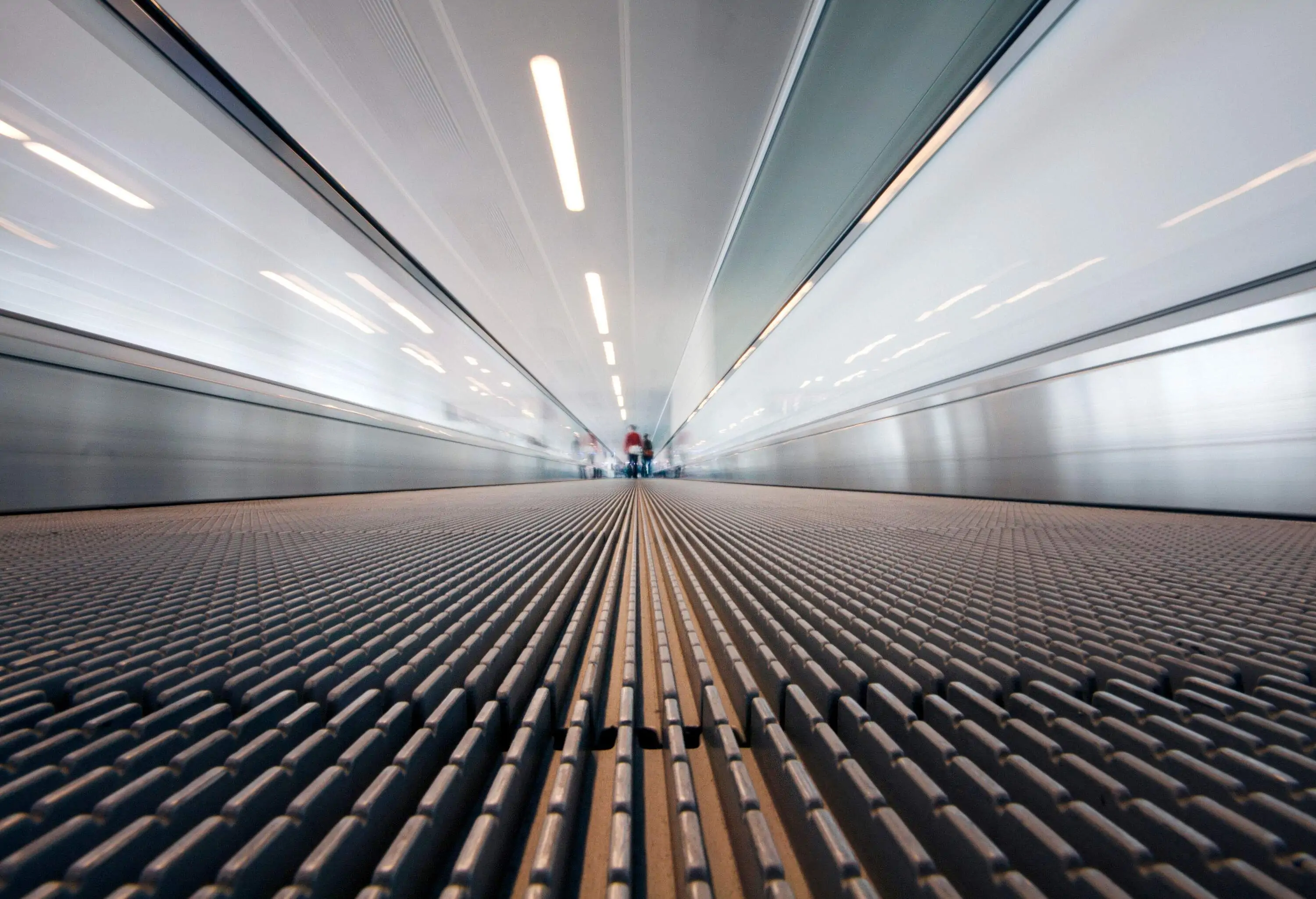 Low angle view from perspective of moving sidewalk in a large international airport