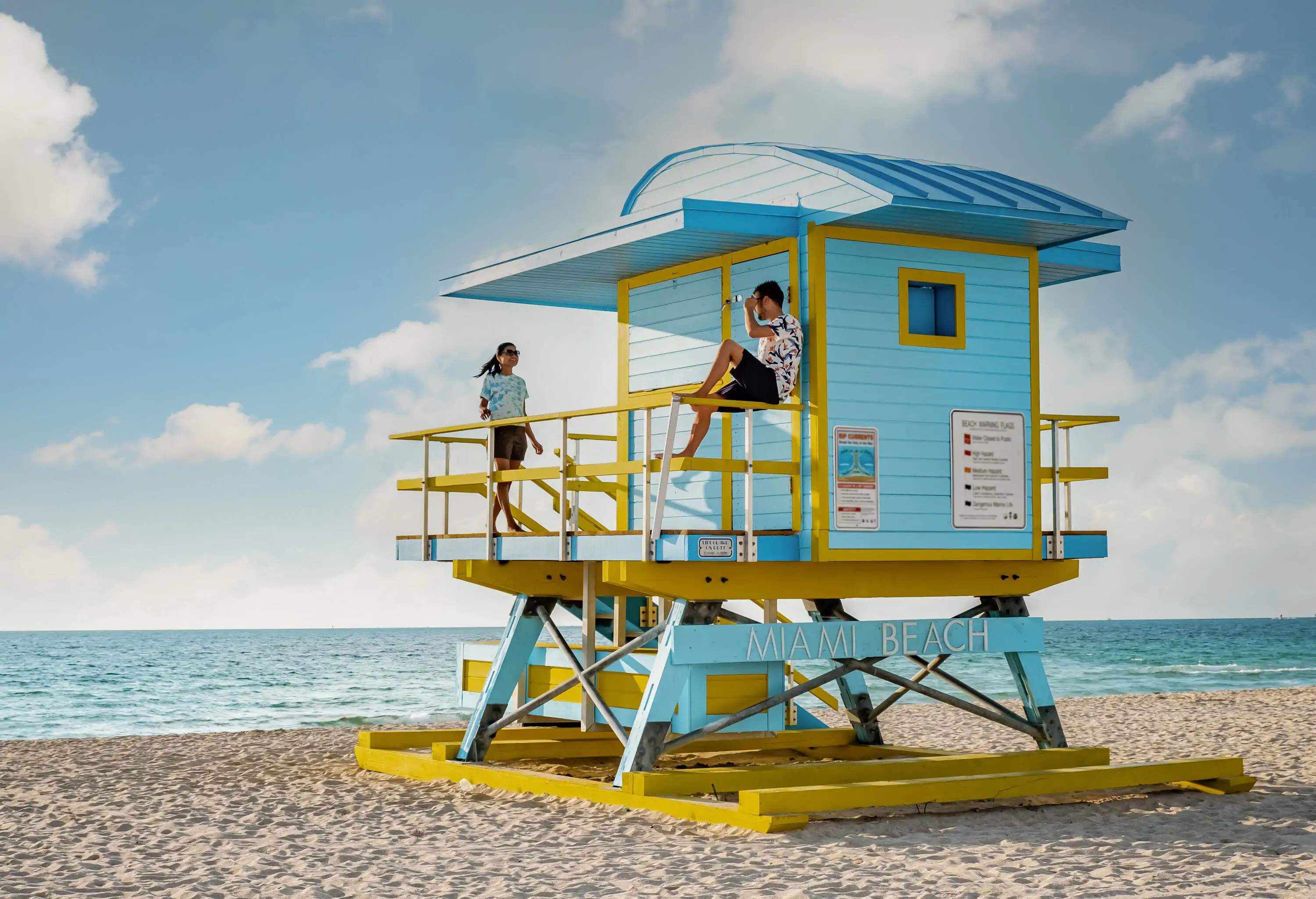 Miami south beach Florida US, couple by lifeguard hut during Sunrise Miami Beach, men, and woman on the beach