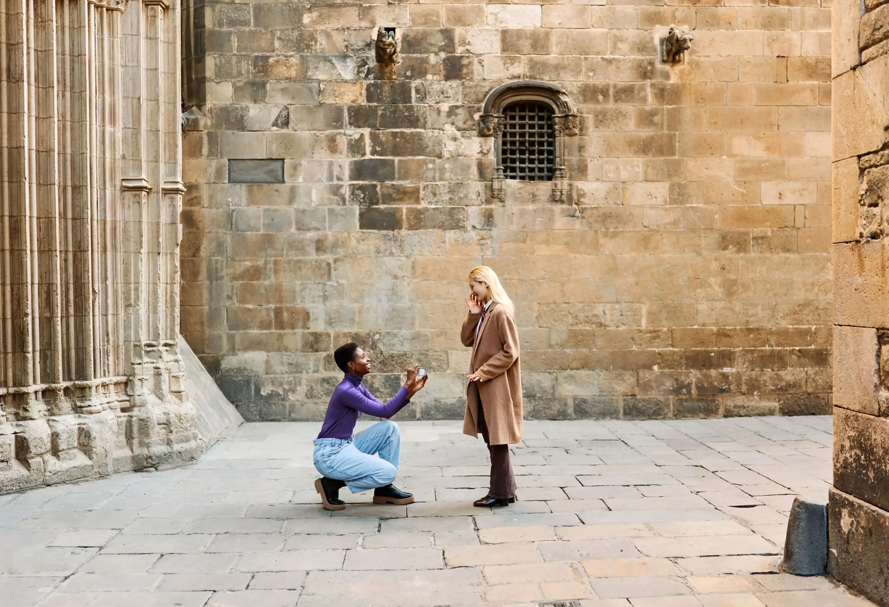 African girl on her knees asking her lesbian partner to marry her on the street