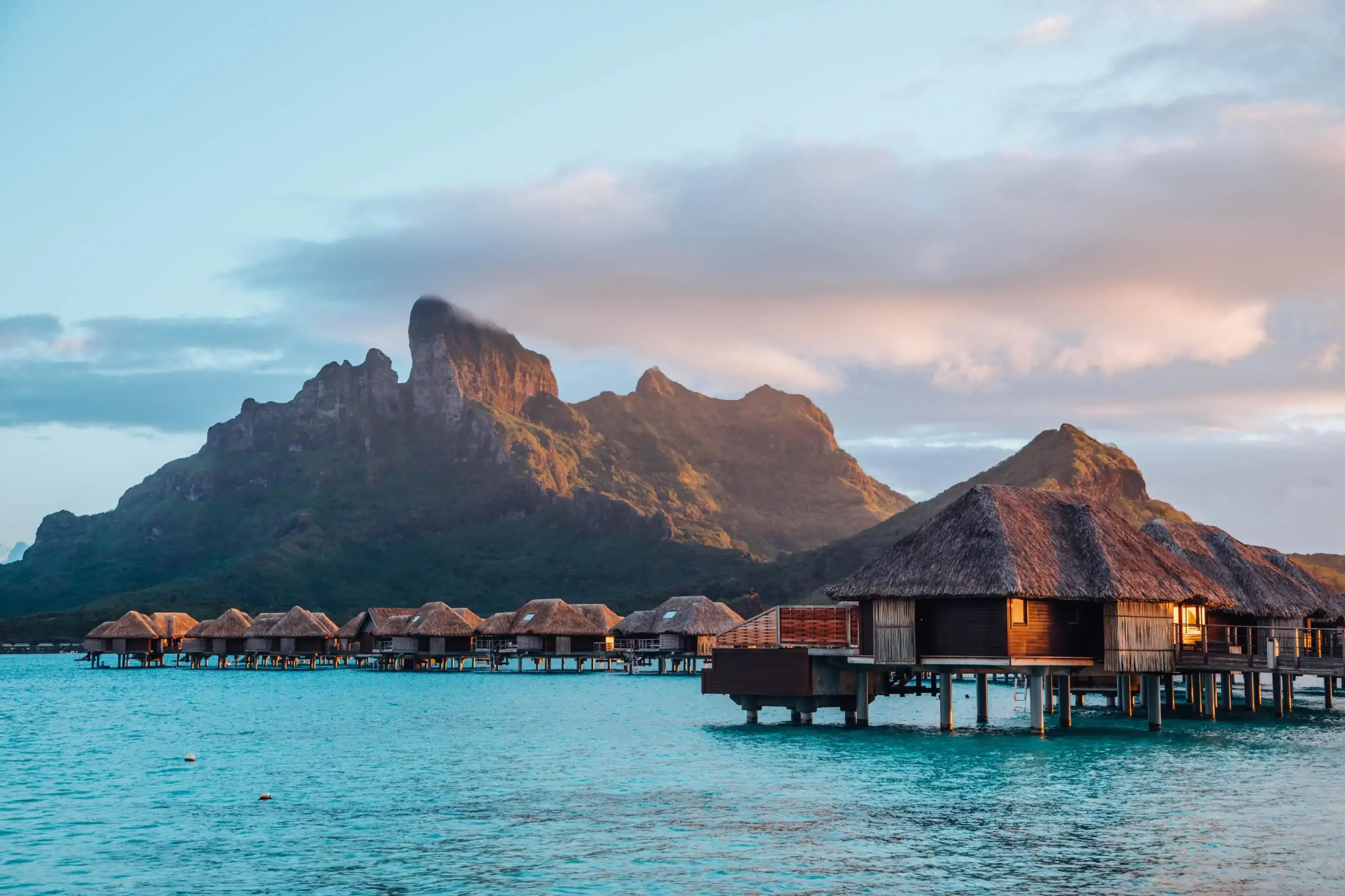 private cabin on stilts by the ocean with mountain in the background