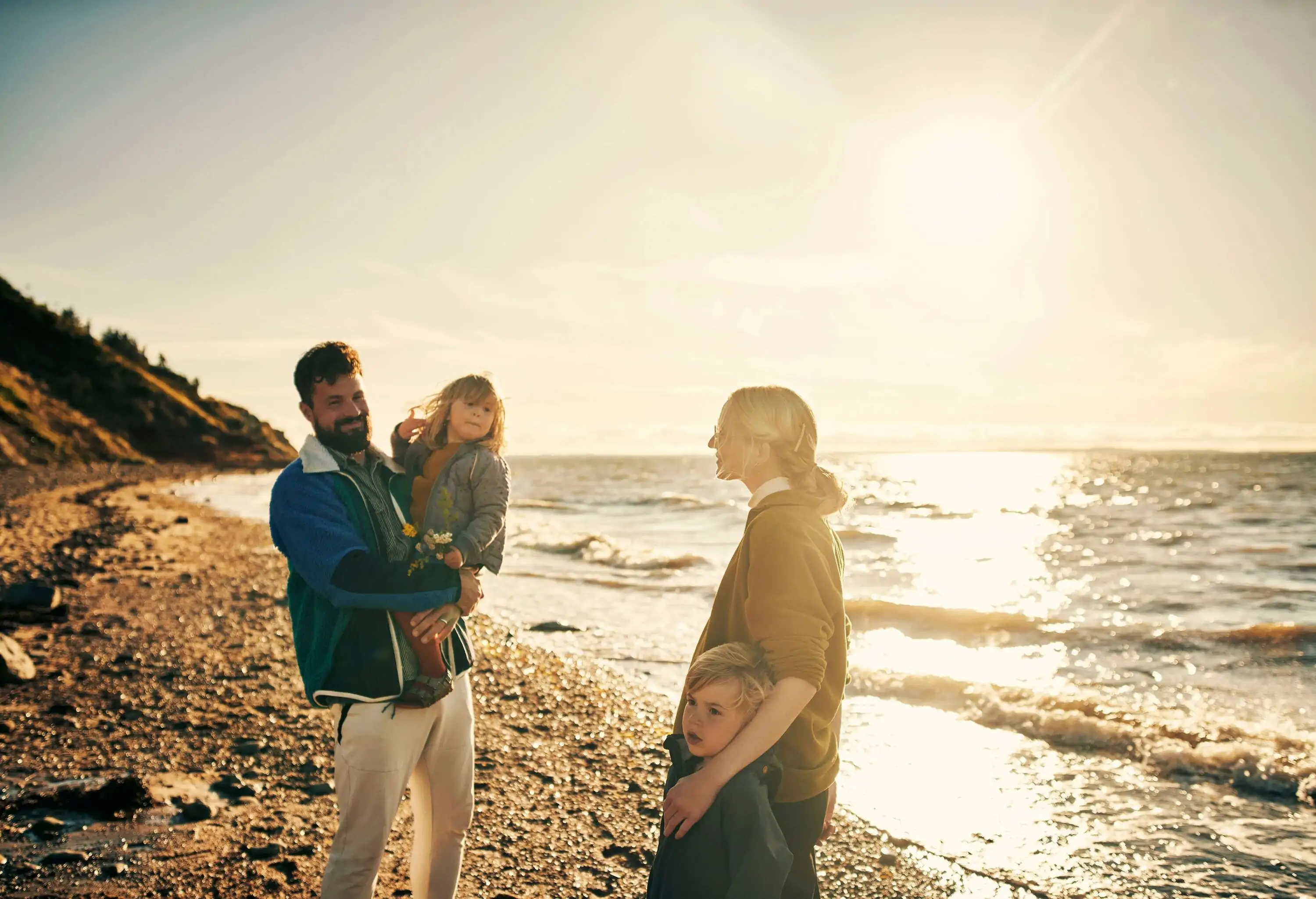 A couple and two small children on a lovely day at the beach.